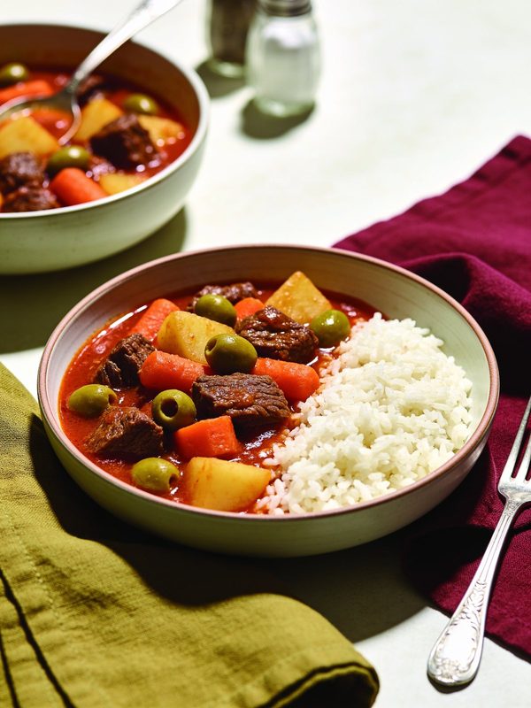 Puerto Rican beef stew with potatoes, carrots and green olives in tomato sauce, served with white rice.