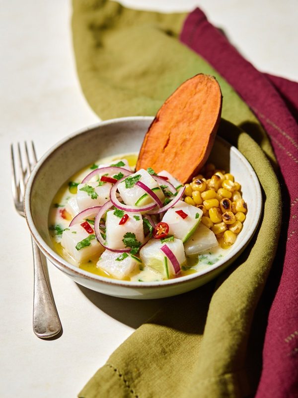 Cubes of white fish in a milky lime marinade with red onion, chili and cilantro, with a slice of sweet potato and toasted corn.